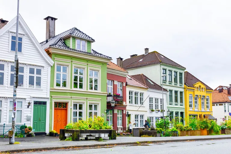 Fargerike trehus på rekke langs en gate i Bergen